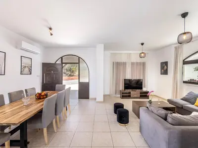 a dining room and living room with a dining table at Villa Socrates in Protaras