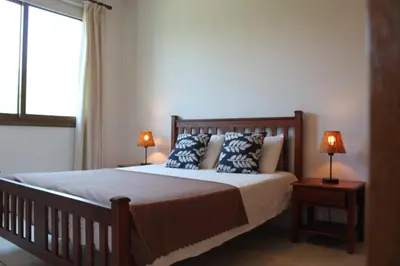 a bedroom with a bed with two lamps and a window at Yiannos House in Evrykhou