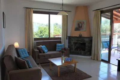 a living room with a couch and a fireplace at Yiannos House in Evrykhou