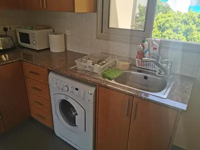 a kitchen with a sink and a washing machine at Sea view apartment in Protaras