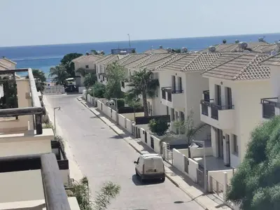a van driving down a street with buildings at Sea view apartment in Protaras