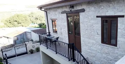 a house with a balcony with a wooden door at Omodos Maria's Apartments in Omodos