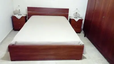 a bed in a room with two night stands and two lamps at Omodos Maria's Apartments in Omodos