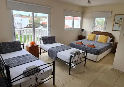 a living room with two beds and a balcony at Villa Julia in Ayia Napa