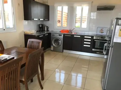 a kitchen with a table and a kitchen with a washing machine at Villa Julia in Ayia Napa