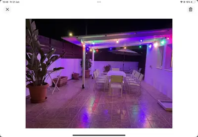 a patio with a table and chairs and purple lights at Villa Julia in Ayia Napa