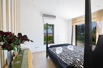 a bedroom with a bed and a large window at Oscar Domain Villa in Protaras