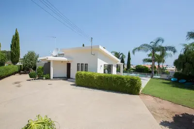 a white house with trees and a driveway at Oscar Domain Villa in Protaras