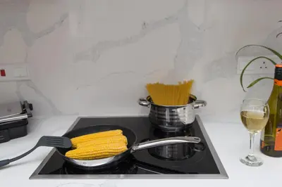 a frying pan on a stove with corn on it at Fig Tree Bay Residences 1 Lantiana Villa in Protaras