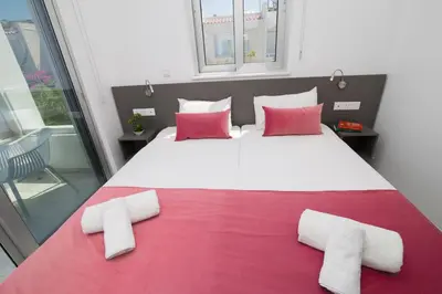 a bedroom with a large bed with red and white pillows at Fig Tree Bay Residences 1 Lantiana Villa in Protaras