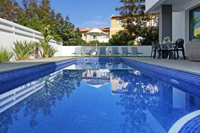 a pool with a table and chairs next to a house at Villa Maritime in Protaras