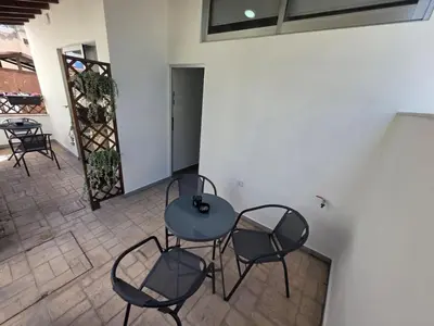 a room with three chairs and a table and a door at Town centre suites in Larnaka