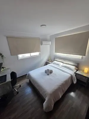 a bedroom with a large white bed and a desk at Town centre suites in Larnaka