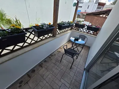 a balcony with a table and chairs and plants at Town centre suites in Larnaka