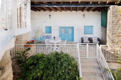 a staircase leading to a house with blue doors at Cottage Houses in Pendakomo
