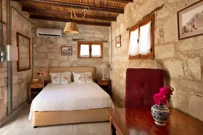 a bedroom with a bed and a table and windows at Cottage Houses in Pendakomo