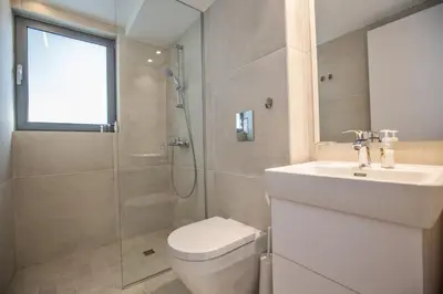 a bathroom with a toilet and a sink and a shower at White Pearl Villa 7 in Protaras