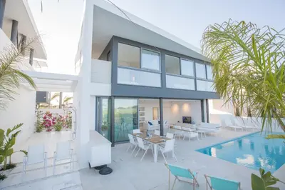 a house with a swimming pool and a patio with a table and chairs at White Pearl Villa 7 in Protaras