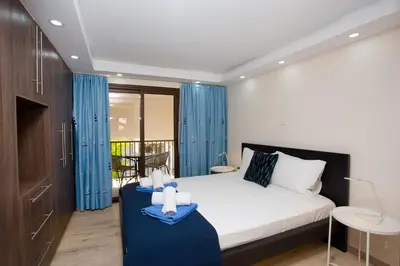 a bedroom with a bed with blue curtains at Galatex Beach Living by TrulyCyprus in Limassol