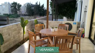 a table and chairs on a patio with a heater at CHRIS'S KYKLADES HOLIDAY APARTMENT in Paralimni