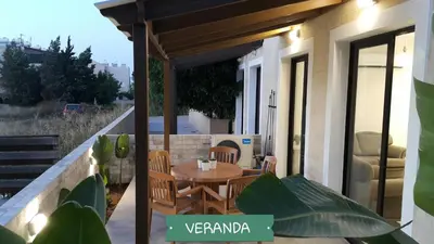 a patio with a table and chairs on a balcony at CHRIS'S KYKLADES HOLIDAY APARTMENT in Paralimni