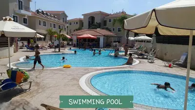 a group of people swimming in a swimming pool at CHRIS'S KYKLADES HOLIDAY APARTMENT in Paralimni