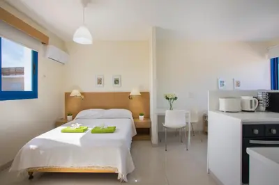 a bedroom with a bed with green towels on it at Flouressia Gardens in Protaras