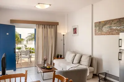 a living room with a couch and a table at Flouressia Gardens in Protaras