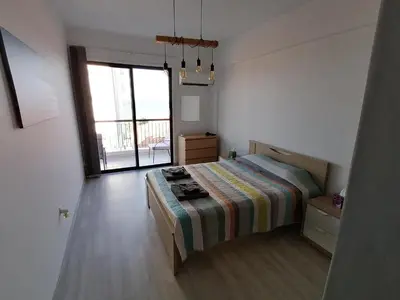 a bedroom with a bed and a large window at Must Stay - Finikoudes Seaview in Larnaka