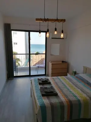 a bedroom with a bed with a view of the ocean at Must Stay - Finikoudes Seaview in Larnaka