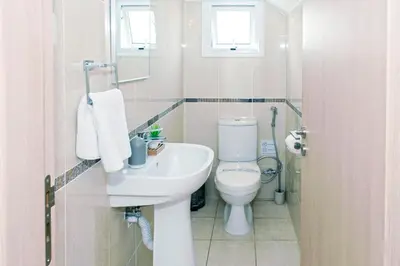 a bathroom with a white toilet and a sink at Nissini Nero, 3 bedroom villa with private pool, 5 min to the beach in Ayia Napa