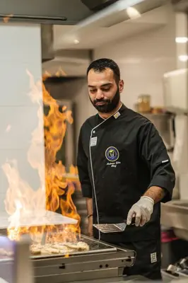 a man standing in a kitchen preparing food at Infinity Blu - Designed for Adults by Louis Hotels in Protaras