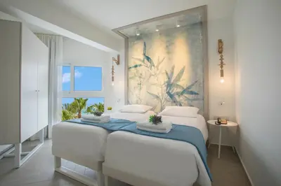 a bedroom with two beds and a painting on the wall at Infinity Blu - Designed for Adults by Louis Hotels in Protaras