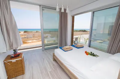 a bedroom with two beds and a large window at Villa Lynn Boutique Beachfront in Ayia Napa