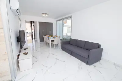 a living room with a couch and a table at Villa Lynn Boutique Beachfront in Ayia Napa