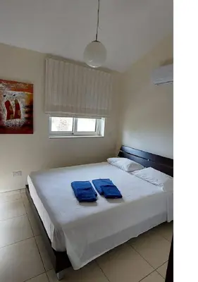 a bedroom with a bed with two blue towels on it at Villa Sorelle in Protaras