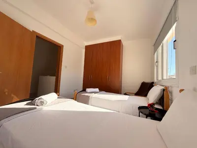a hotel room with two beds and a window at Lovely holiday home,Kapparis,2 swimming pools,Wifi in Paralimni