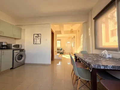 a kitchen and dining room with a table and chairs at Lovely holiday home,Kapparis,2 swimming pools,Wifi in Paralimni