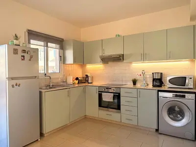 a kitchen with a refrigerator and a dishwasher at Lovely holiday home,Kapparis,2 swimming pools,Wifi in Paralimni