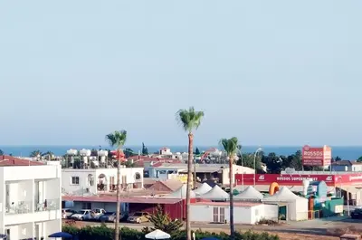 a view of a city with palm trees and houses at Nissini Blanco, 3 bedroom villa with private pool, 5 min to the beach in Ayia Napa