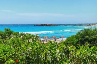 a sandy beach with umbrellas and the ocean at Nissini Blanco, 3 bedroom villa with private pool, 5 min to the beach in Ayia Napa