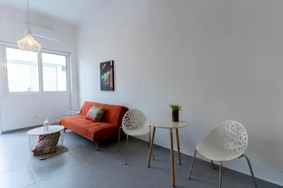 a living room with a couch and a table and chairs at Prima Gardens City Studios in Larnaka