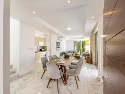 a dining room and living room with a table and chairs at Milos lifestyle villa H30 in Protaras