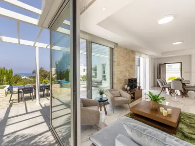 an open living room with glass doors and a dining room at Milos lifestyle villa H30 in Protaras
