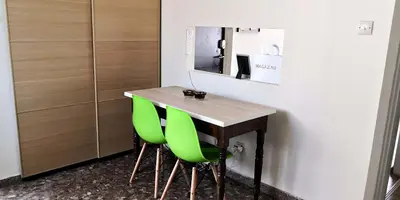 a table with green chairs in a room at The Bridge-House Apartment in Nicosia