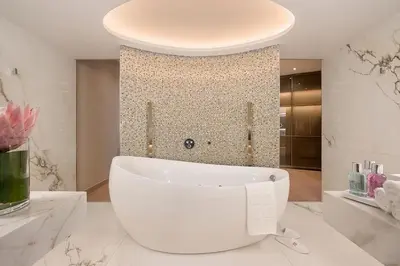 a white bathroom with a tub and a shower at Four Seasons Hotel in Limassol