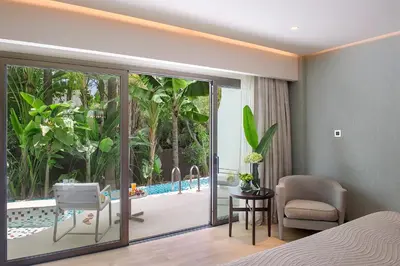 a bedroom with a bed and a chair and a pool at Four Seasons Hotel in Limassol