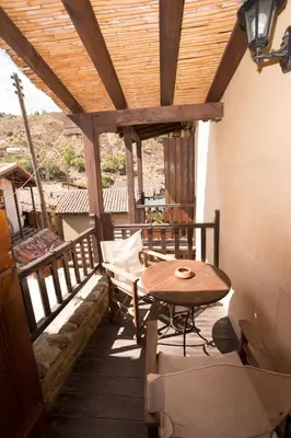 a porch with a table and a bench on a balcony at Linos Inn in Kakopetria