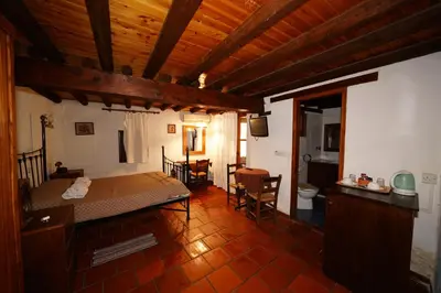 a bedroom with a bed and a table and chairs at Linos Inn in Kakopetria