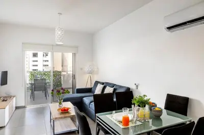a living room with a blue couch and a table at AirBnSea City Centre Side Sea view Apartments in Larnaka